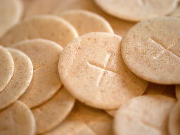 Close-up of communion wafers with a cross imprint.