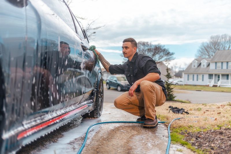 Auto Detailing - Man Washing Car with Micorfiber Towel - Wide Angle