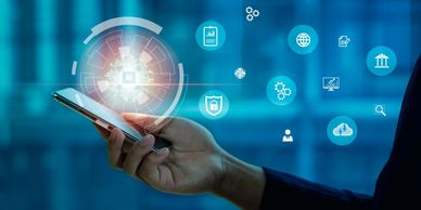 Hand holding smartphone with digital security icons floating around.