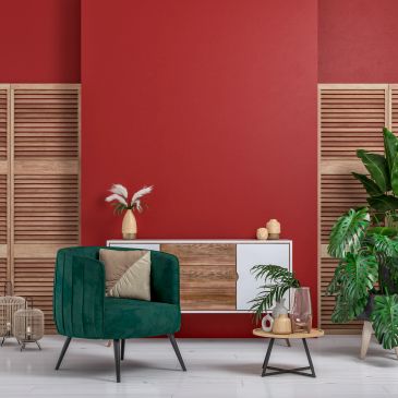 Modern living room with green armchair and red accent wall.