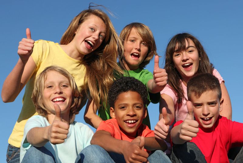 Diversity, mixed group of diverse kids tweens, or children holding thumbs up at summer camp