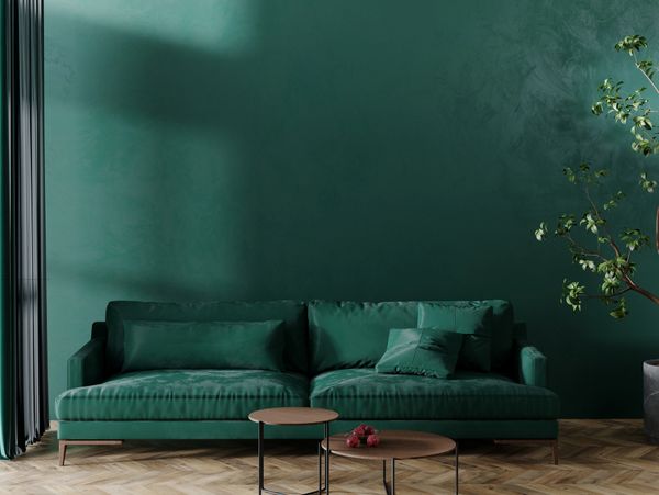 Modern green velvet sofa with matching cushions in a stylish living room.