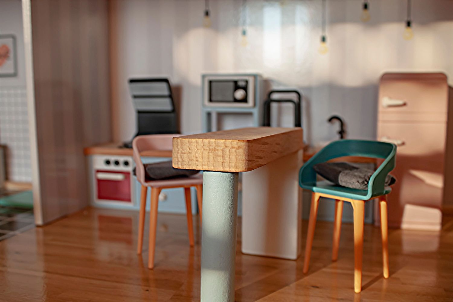 Miniature kitchen scene with tiny chairs and appliances.