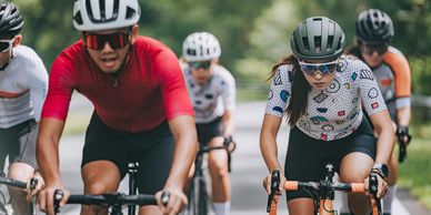 Group of cyclists racing on a road surrounded by greenery.