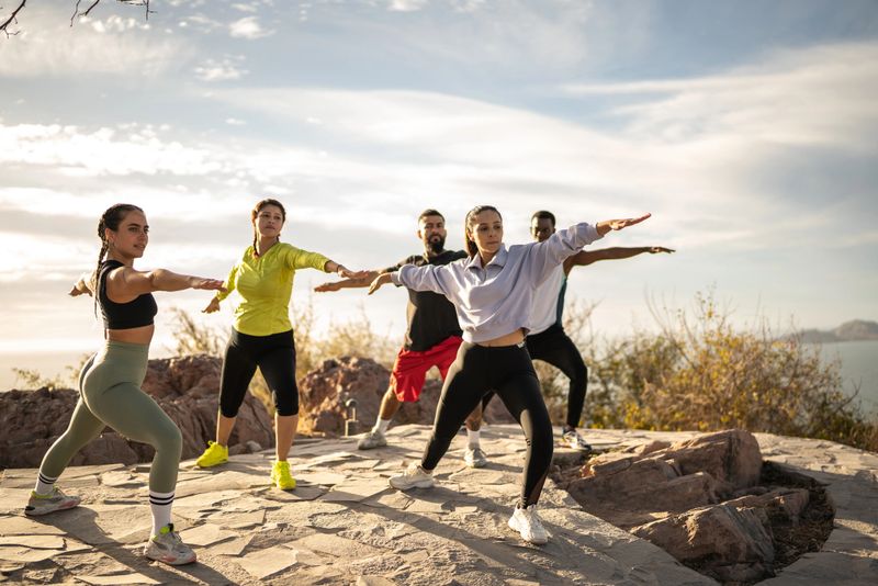 Mid adult yoga instructor woman giving an yoga class outdoors