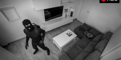 Masked person in a living room caught on security camera.