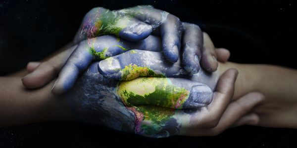 Hands intertwined with a superimposed image of Earth, symbolizing unity and care.