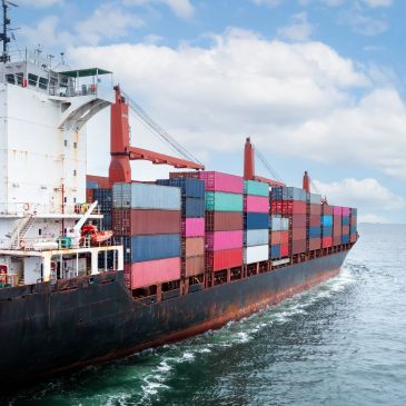 Containerschiff auf dem Meer mit bunten Containerstapeln.
