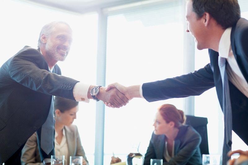 Businessmen shaking hands in conference room