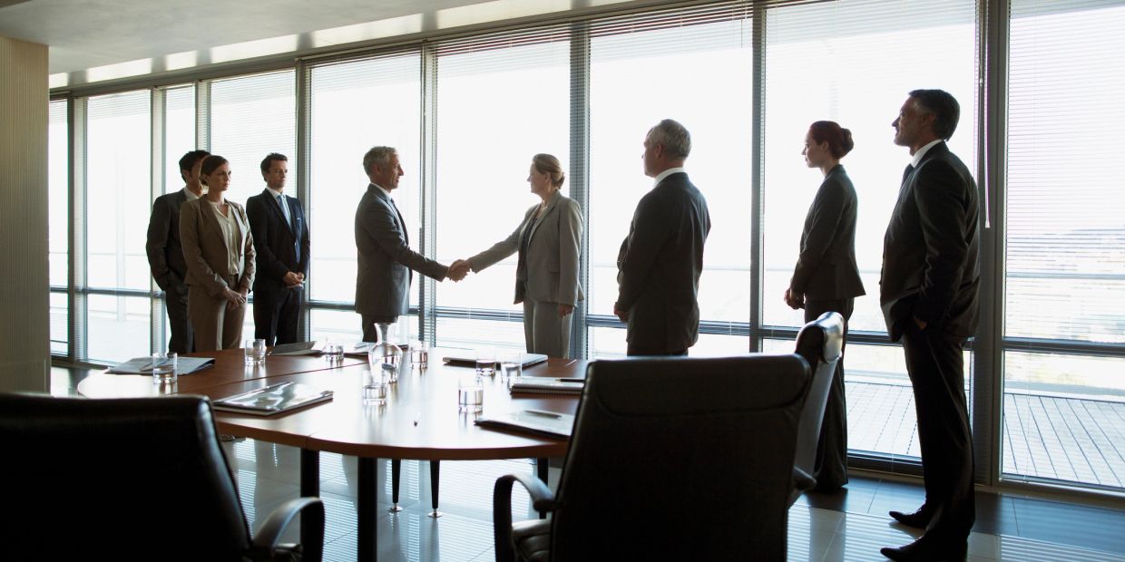 Business professionals shaking hands in a conference room.