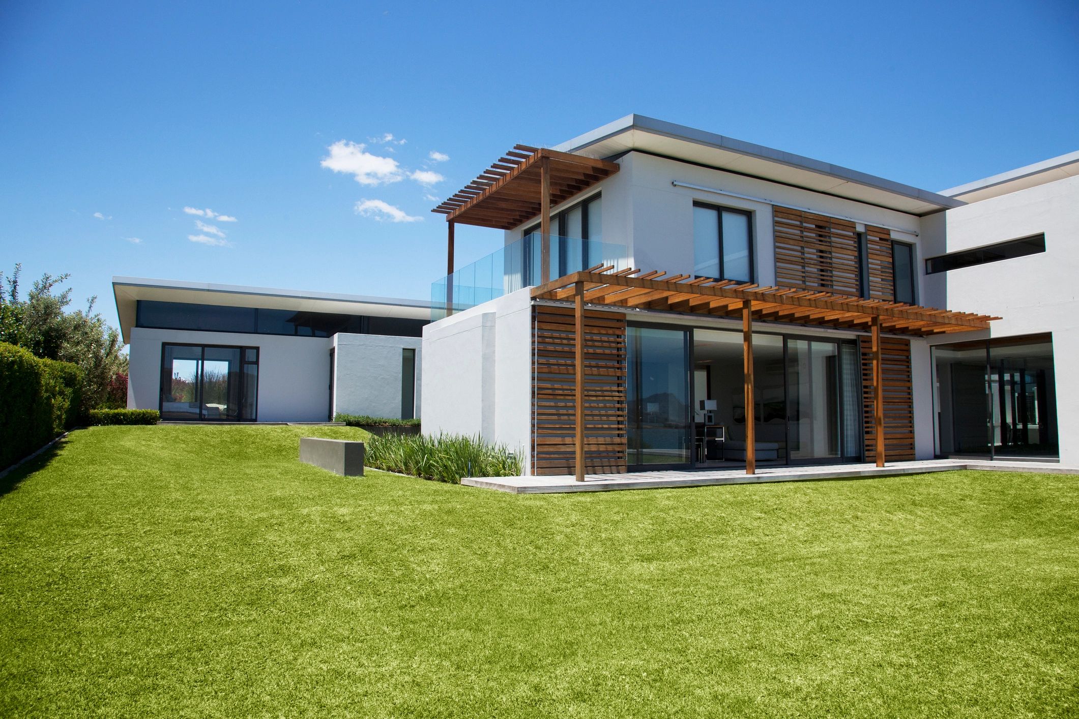 Casa moderna con jardín amplio y cielos despejados.