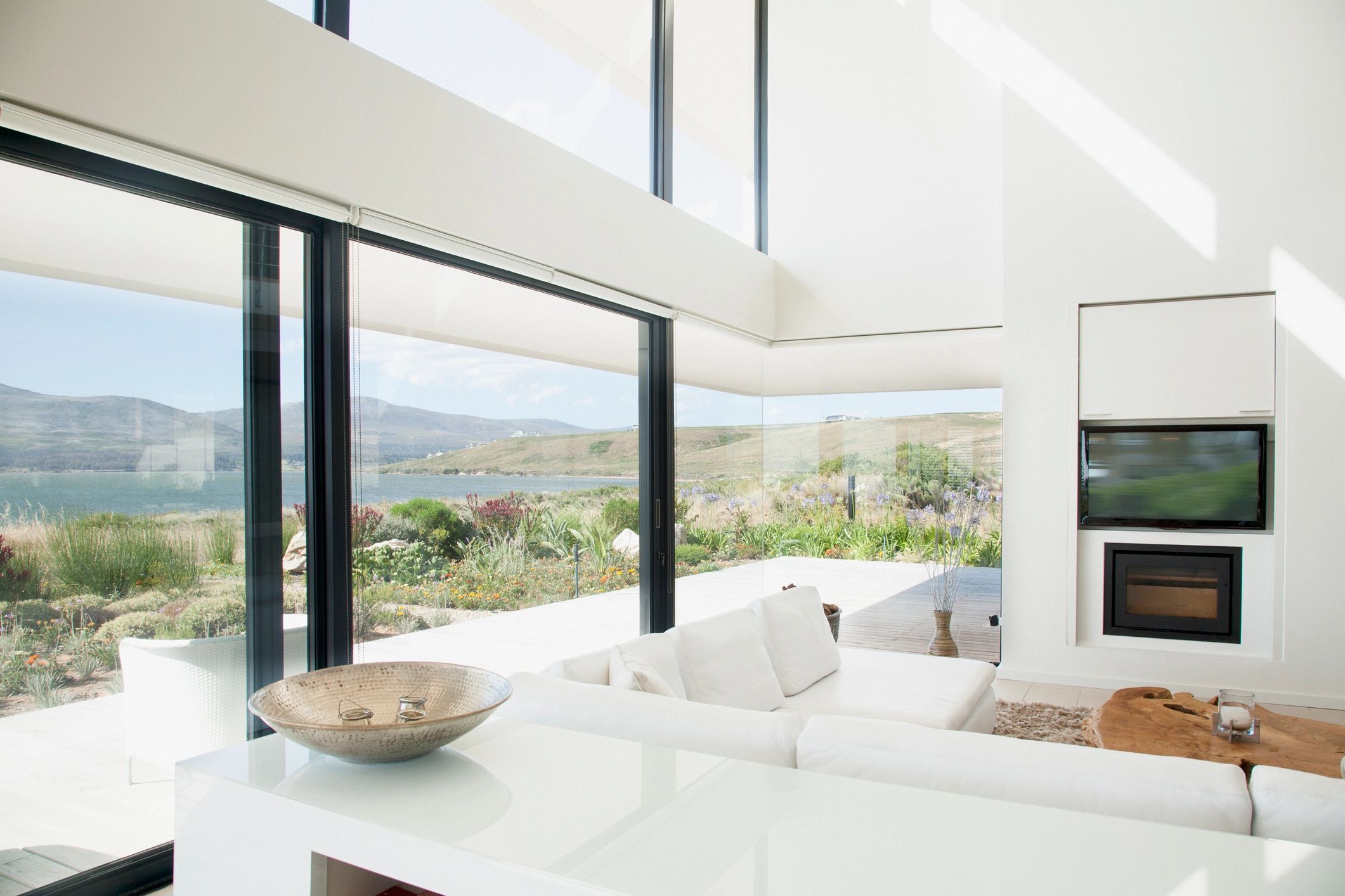 Bright modern living room with large windows showcasing scenic outdoor views.