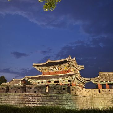 Traditional Korean palace illuminated under a twilight sky.