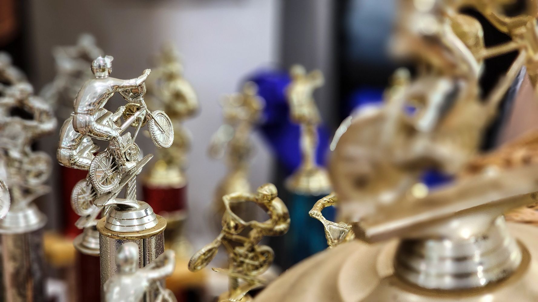 Close-up of BMX bike trophies with riders performing tricks.