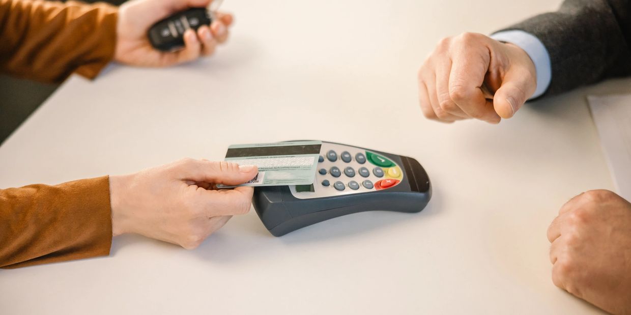 A person making a payment with a credit card at a terminal.
