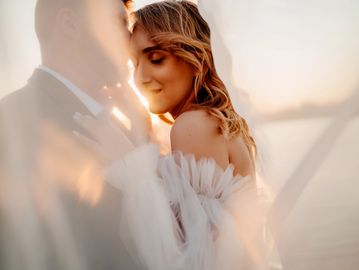 A couple sharing an intimate moment at sunset.