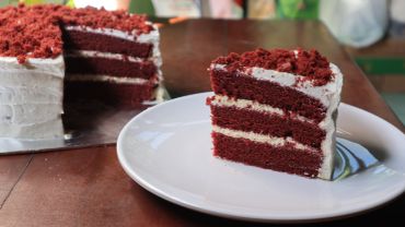 Slice of red velvet cake on plate.