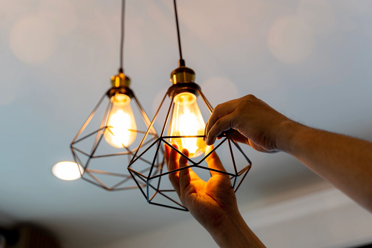 electrician replacing light bulb in light fixture