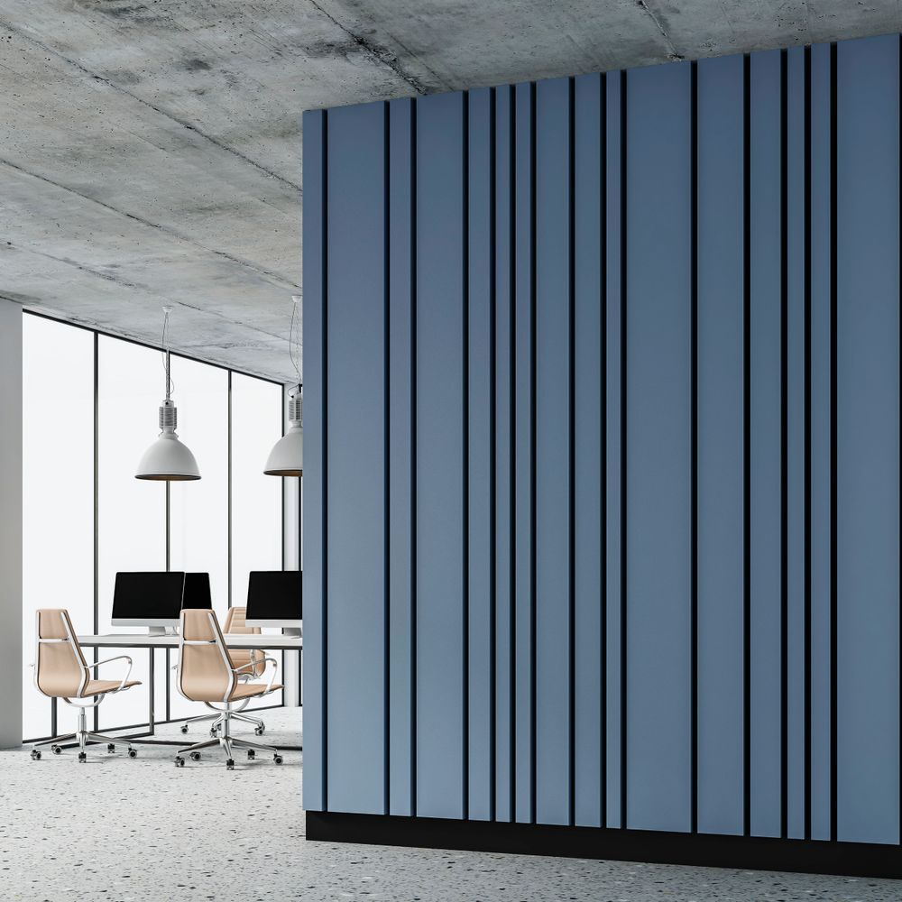 Modern office space with beige chairs, computers, and blue textured wall panels.