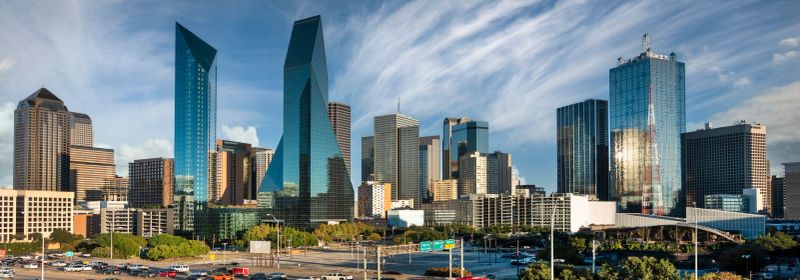 Downtown city skyline panorama view of the modern financial district buildings over the traffic on the highway in Dallas Texas USA