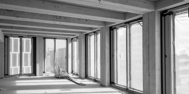 Empty modern room under construction with large windows.