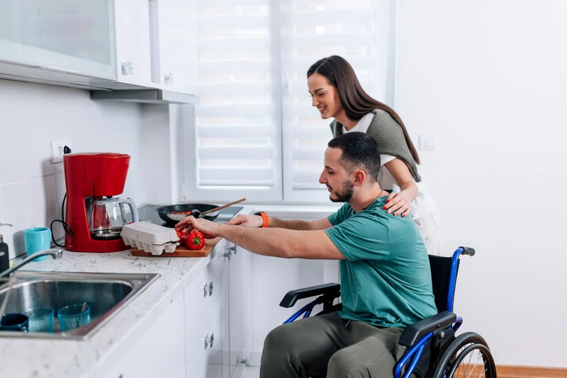 A young Caucasian woman is standing next to her young Caucasian male friend, while he's preparing lunch.