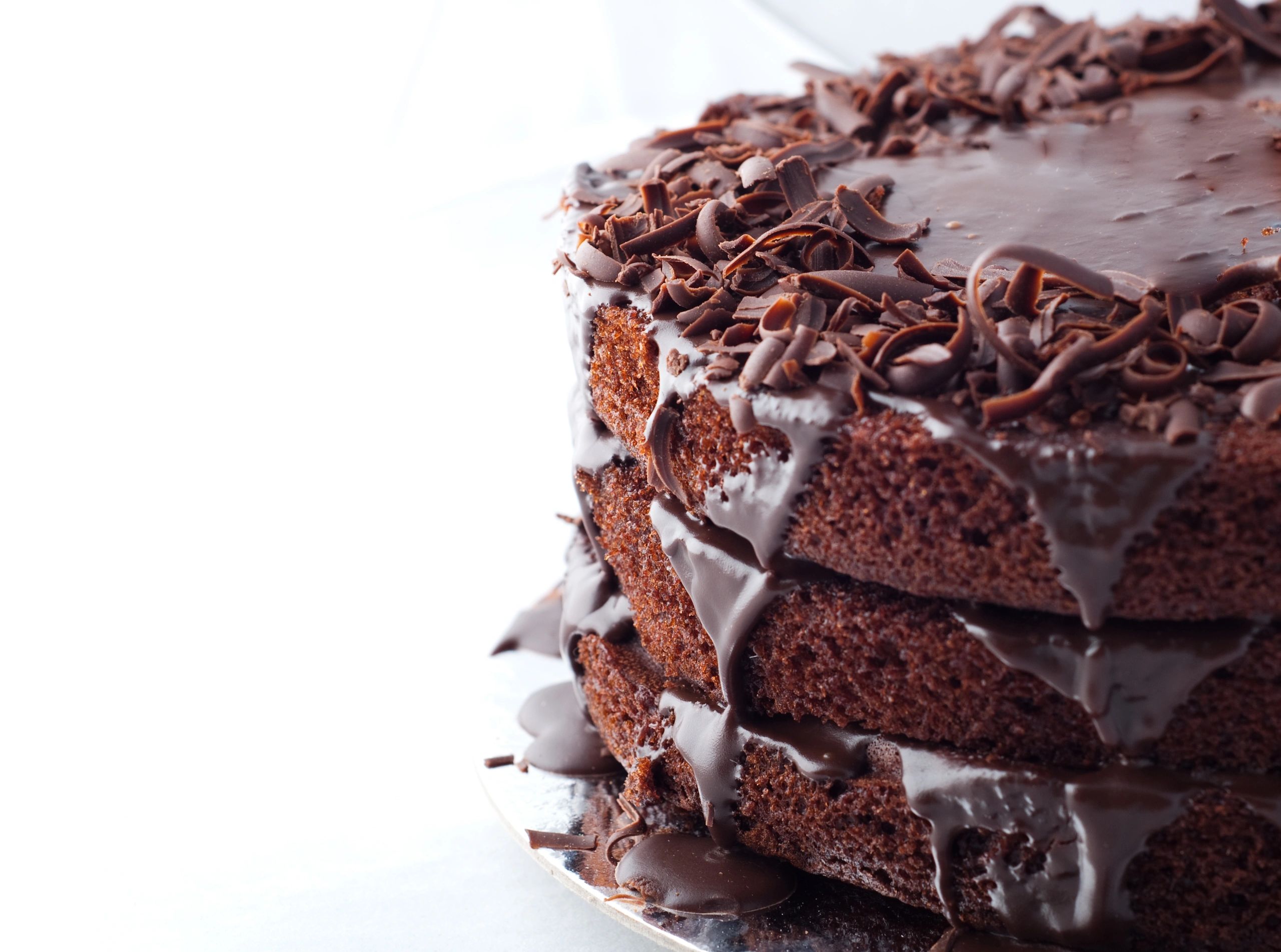 Three-layer chocolate cake with dripping ganache and chocolate shavings.