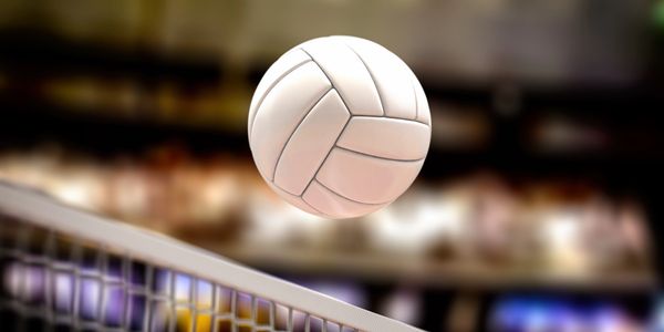A volleyball flying over the net during a game.