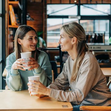 Two ladies drinking a hot drink during a menopause coaching session