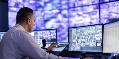 Man monitoring multiple surveillance screens.