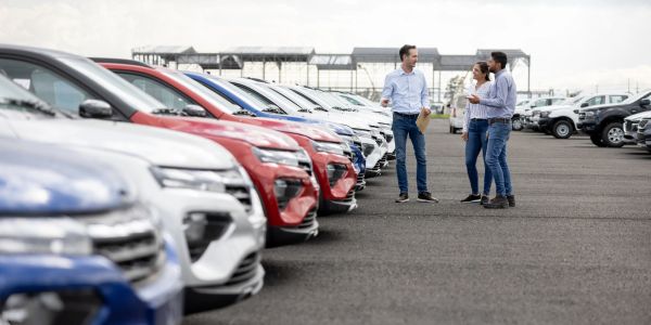 Otomobil parkında üç kişi konuşuyor.