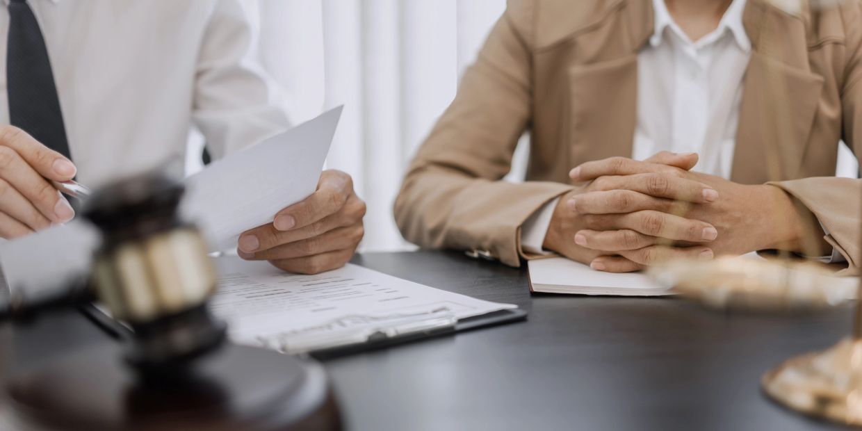 Two professionals discussing documents in a legal setting.