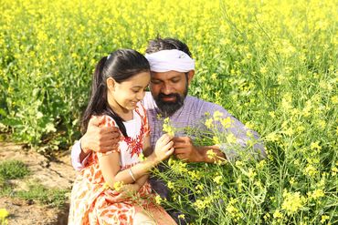 Father and daughter enjoying mustard field together.