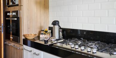 Modern kitchen countertop with gas stove and coffee setup.