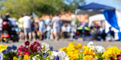 festival with people in the background; colorful, summer flowers in the foreground
