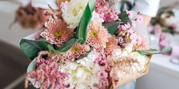 A bouquet of pastel flowers with greenery.