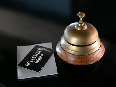Hotel-style service bell on a countertop next to a card reading "press for help" 