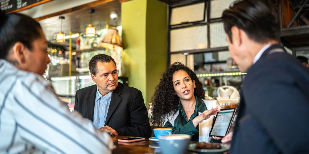 Group of people having a business discussion in a cafe.