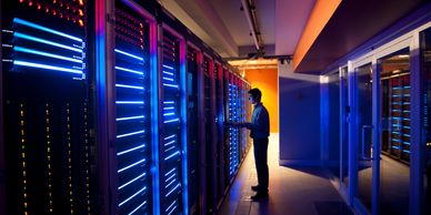 Technician working on servers in a brightly lit data center.