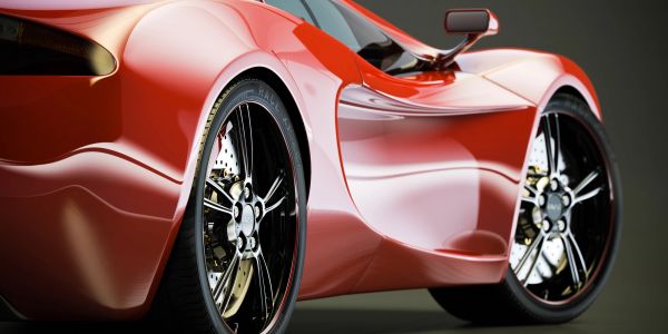 Sleek red sports car showcasing its glossy finish and detailed wheels.