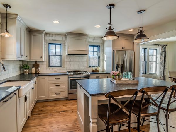 Bright modern kitchen with island seating and stainless steel appliances.