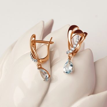 "Elegante gouden oorbellen met blauwe druppelvormige edelstenen en diamantaccenten."