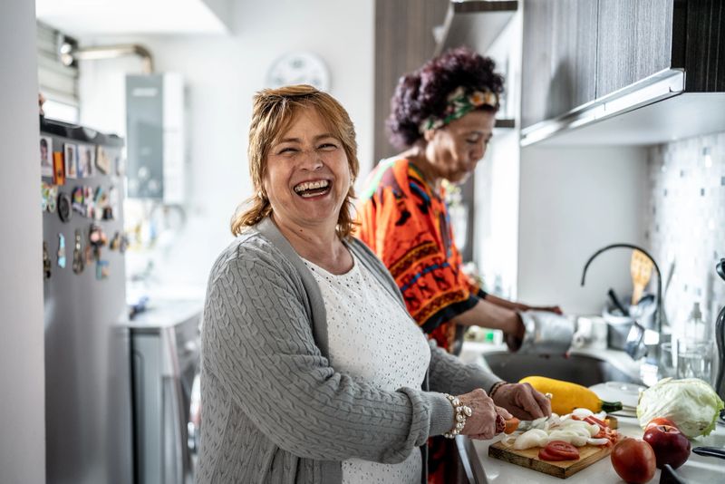 Portrait of a mature woman cutting vegetables in the kitchen at home