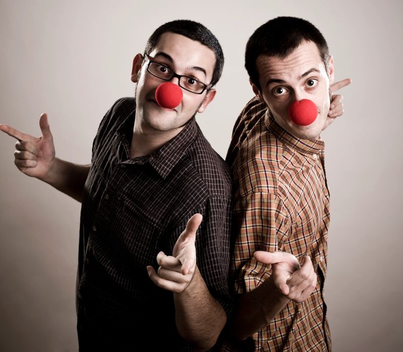 A pair of surprising clowns, pointing and looking ahead.