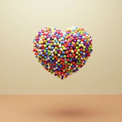 Colorful heart shape made of small spheres.