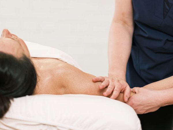 Massage therapist performing manual lymphatic drainage therapy at Wholly Spirit Hands Sugar Land.