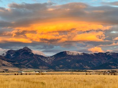 Golden sunset clouds over mountain range and farmland fields.