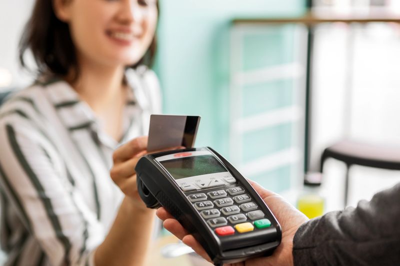 Smiling young woman making payment with credit card
