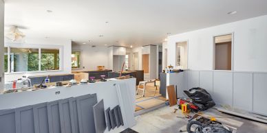 Interior of a house under renovation with construction materials scattered around.