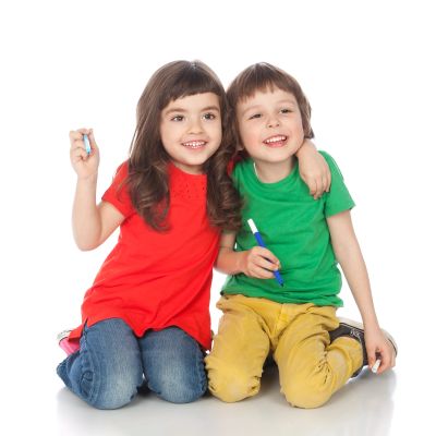 Two children smiling and sitting close together.